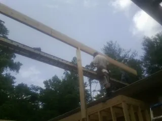 Carpenter setting a ridge beam over a new addition frame — Ice Dam Removal by Roofing Brothers in Amawalk
