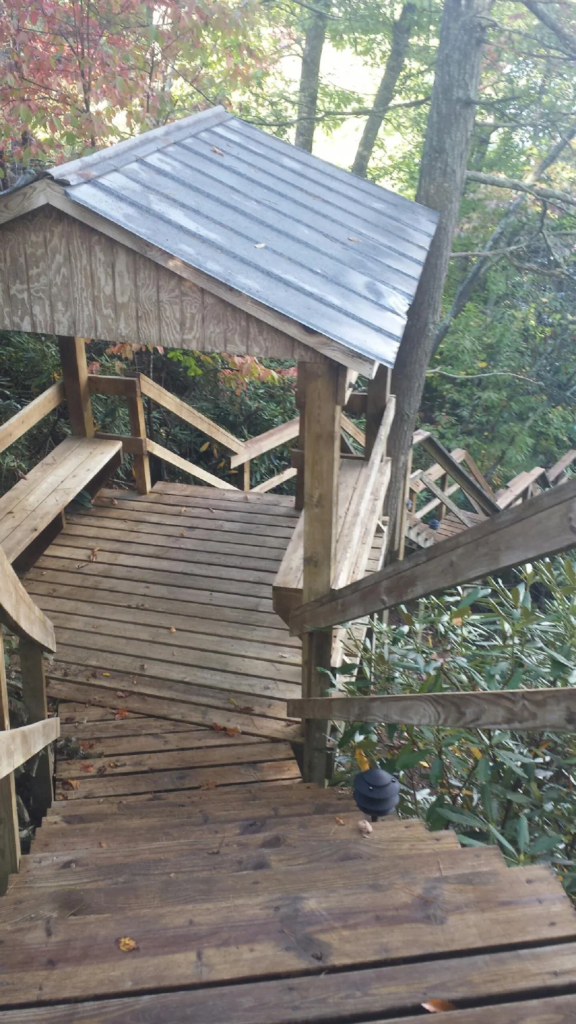Metal roofed shelter over wooden steps on a wooded walkway — Skylight Repair & Installation work by our crew in Amawalk