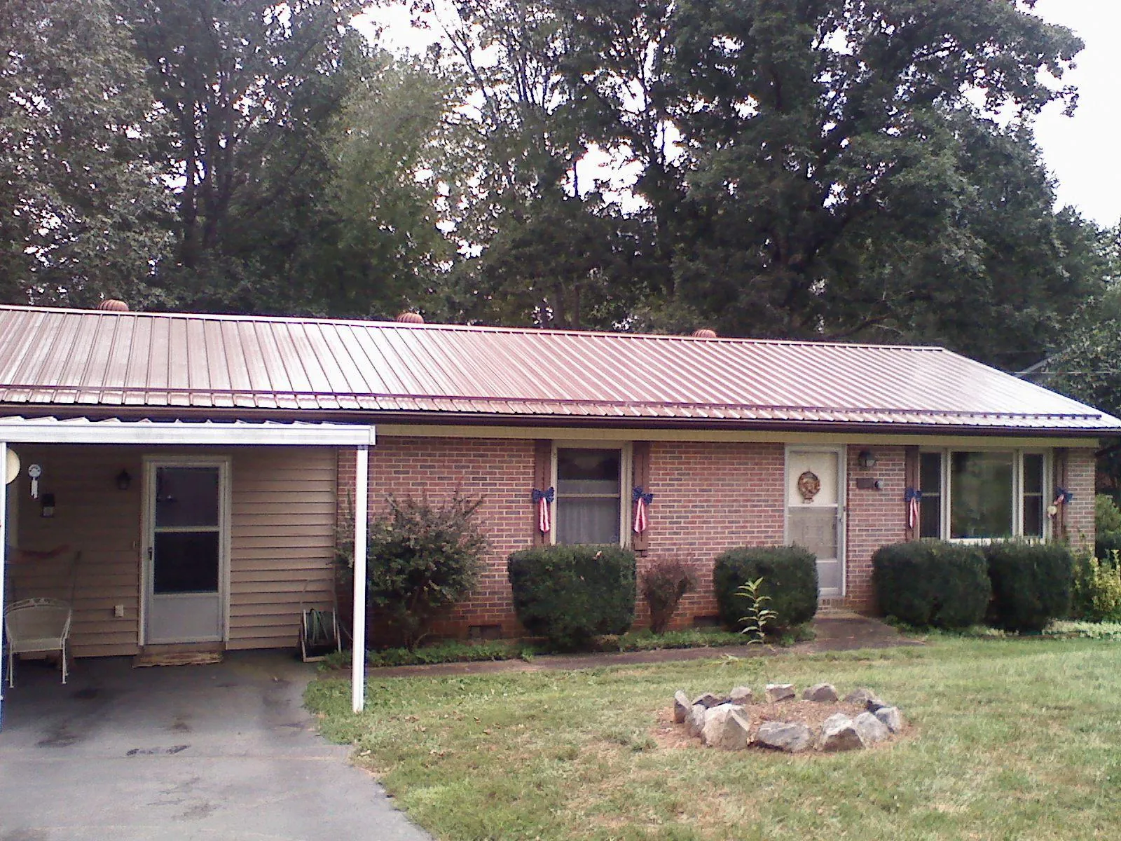 Bronze metal roof and carport on a brick ranch home — Roof Repair work by our crew in Amawalk